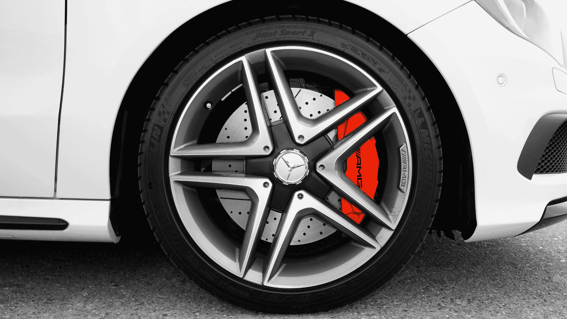 Michelin renkaan merkinnät lähikuvassa valkoisen AMG-Mersun alla.
